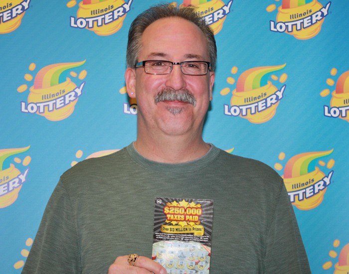 Tobias Bloom holds his winning $250,000 Taxes Paid instant ticket.